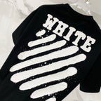 Black T-shirt closeup with 'WHITE' striped graphic print