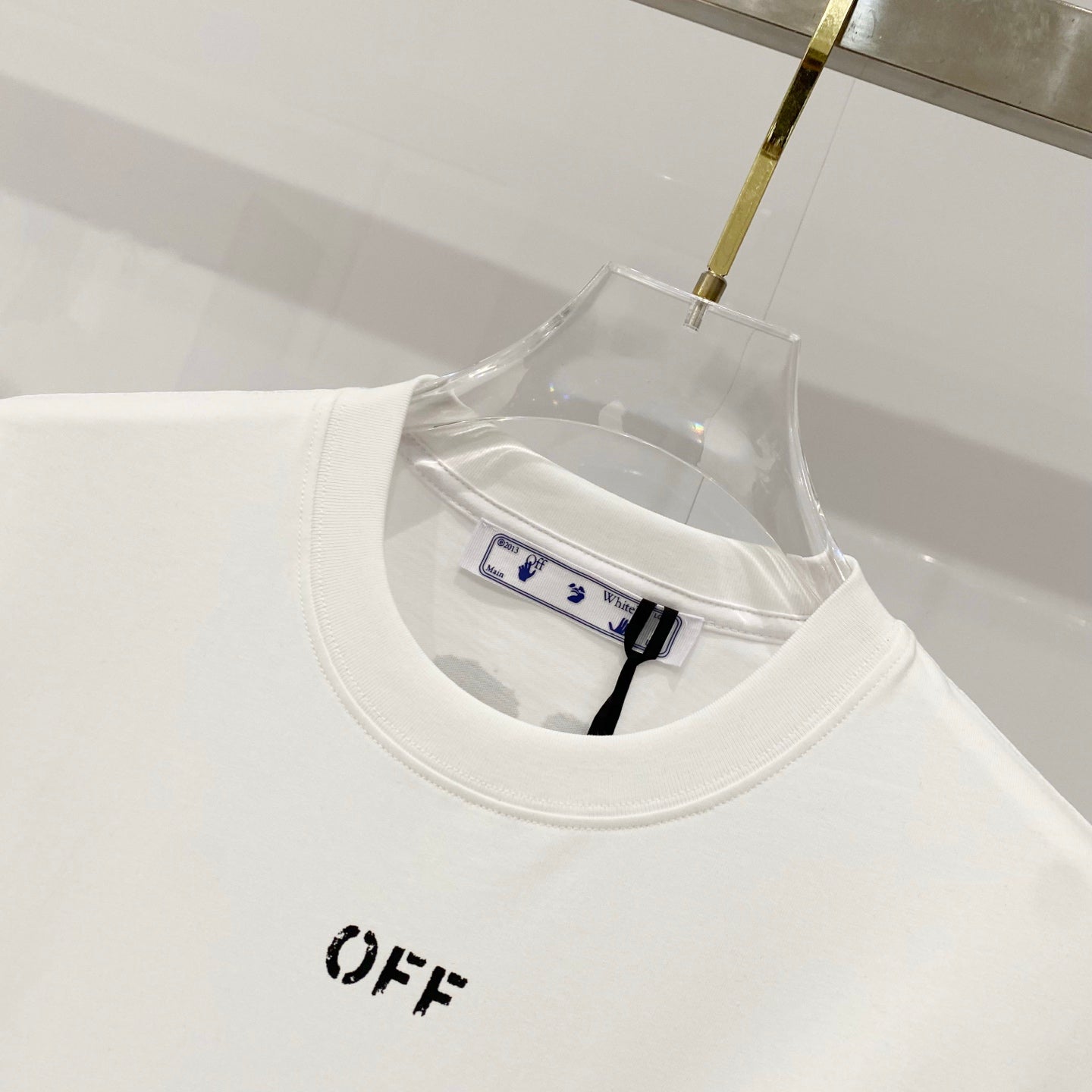 White crew-neck T-shirt with small “OFF” logo print on the chest