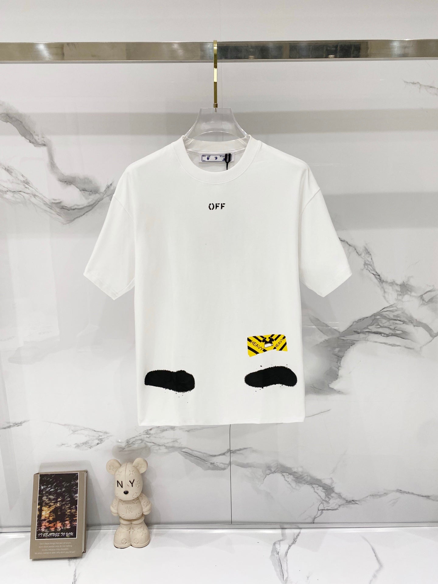 White T-shirt with small chest logo print and black graphic accents