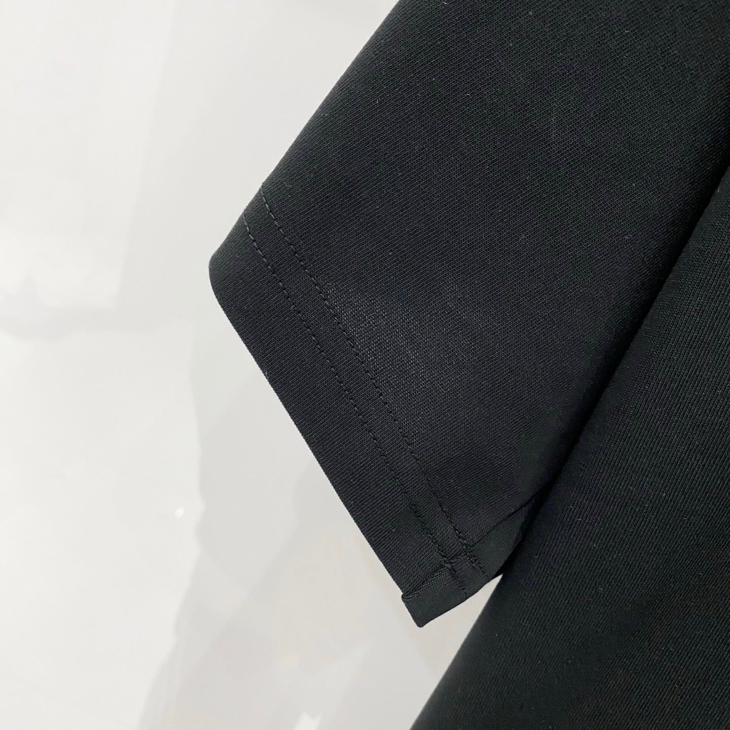 Black T-shirt sleeve hem with neat stitched edge