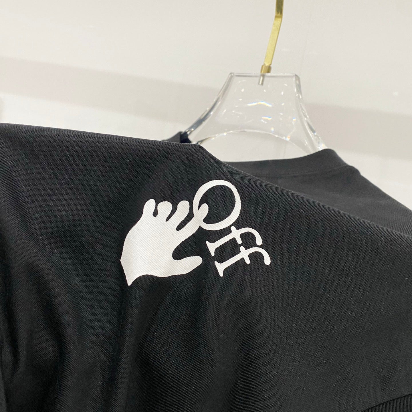 Black T-shirt with large white hand logo print on back