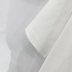 Off-white t-shirt sleeve and hem close-up with visible stitching.