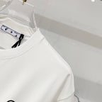 Off-white t-shirt side view on a clear hanger, with partial front logo visible.