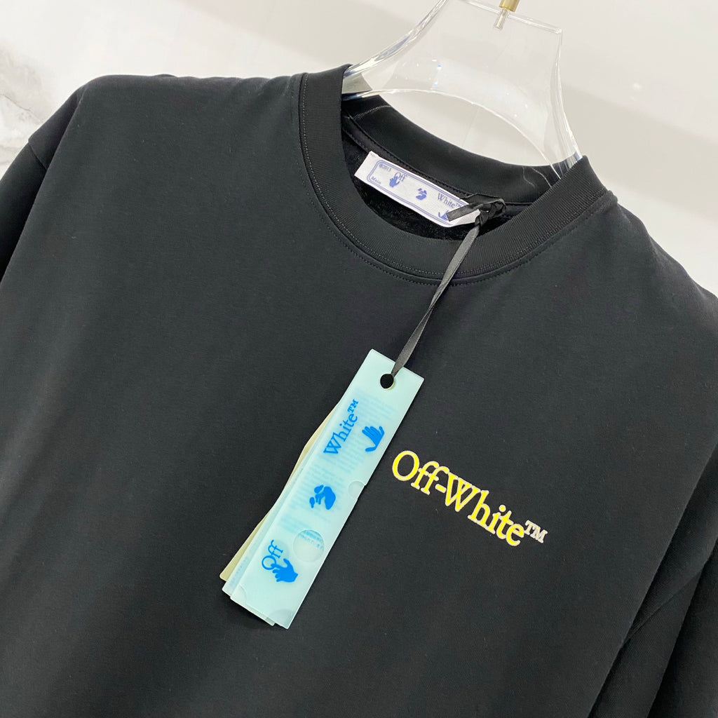 Black T-shirt with yellow Off-White chest logo and attached garment tag.