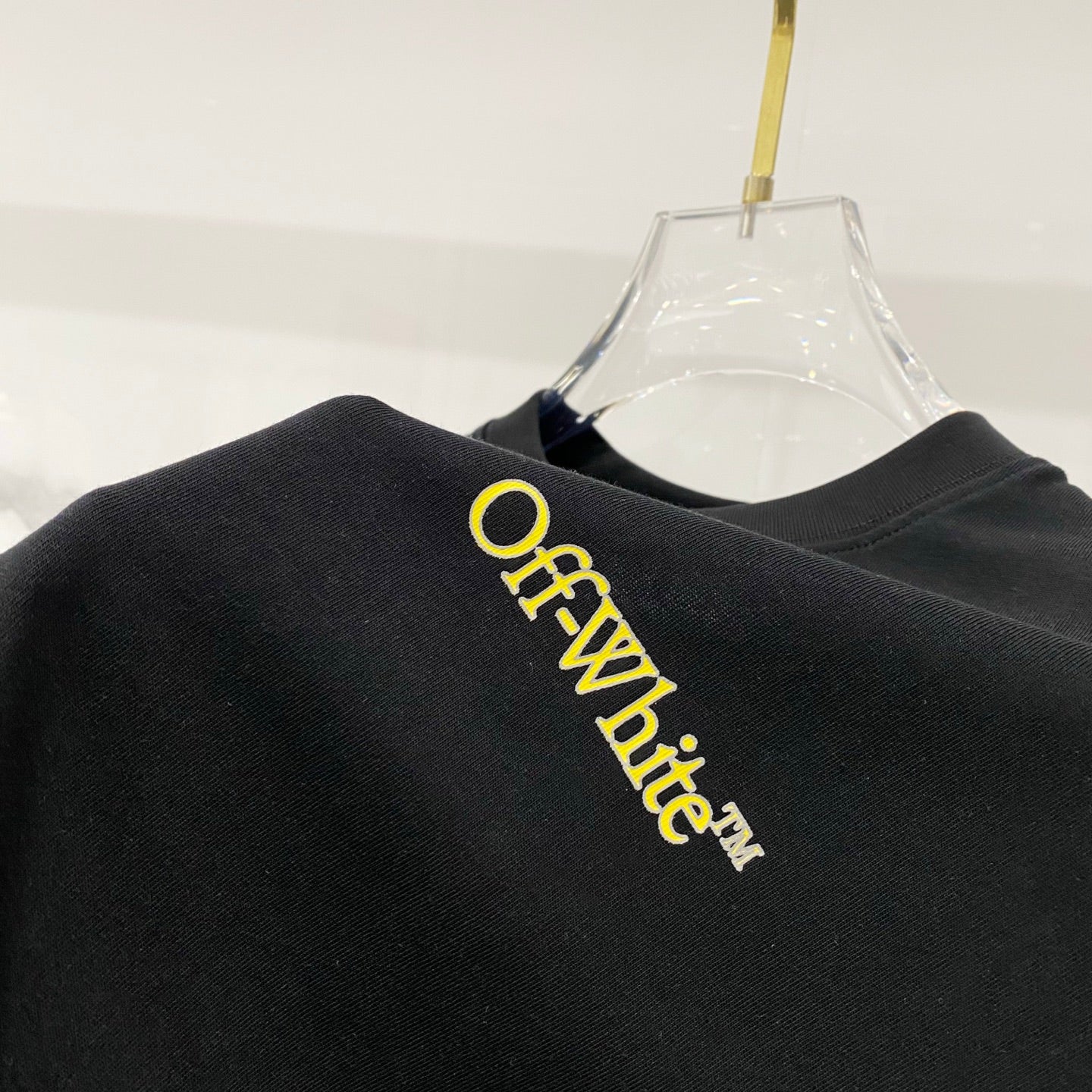 Black T-shirt back with yellow Off-White logo lettering.