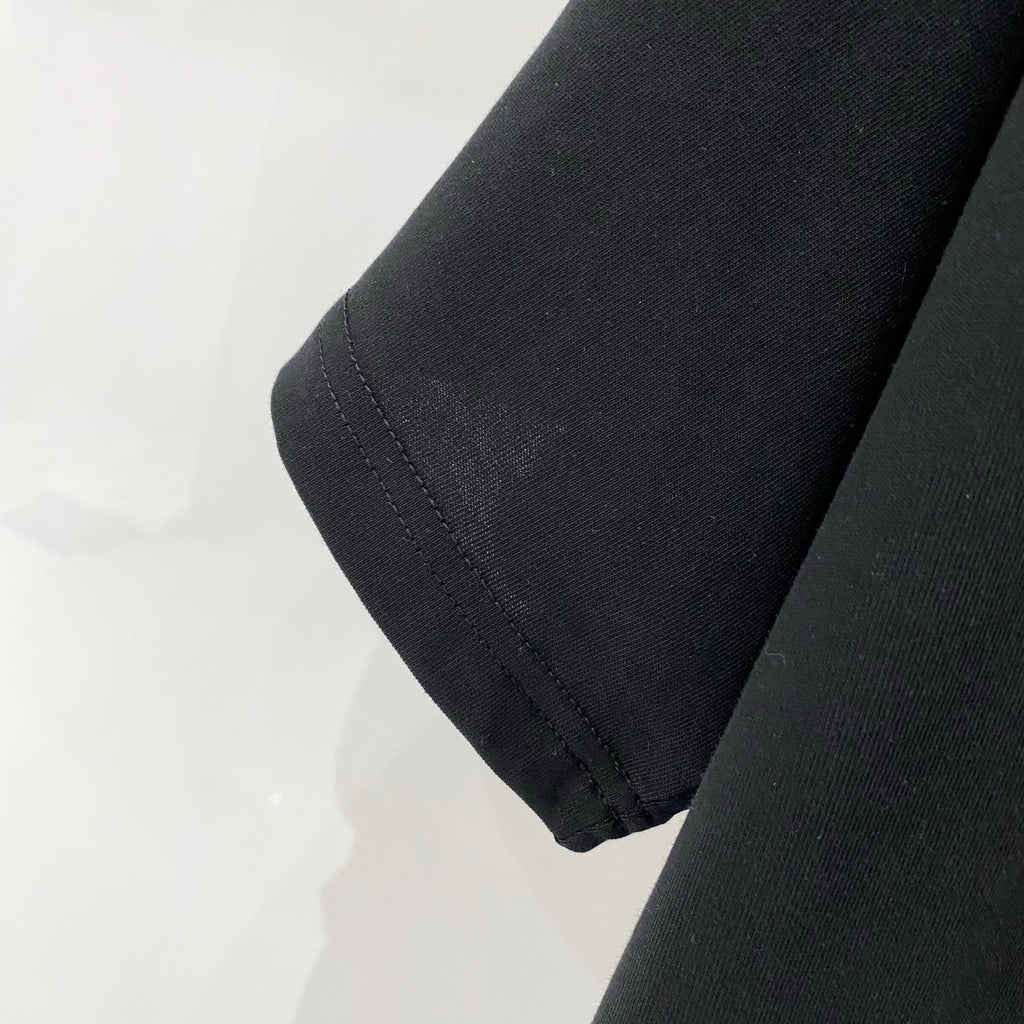 Black T-shirt sleeve hem with stitched seam.