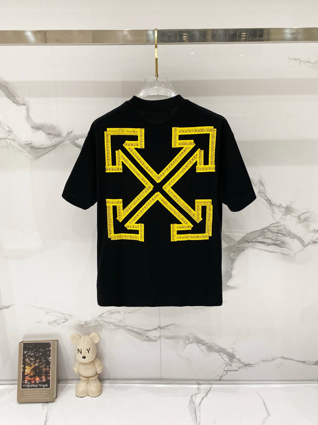 Black T-shirt with large yellow Off-White arrows graphic on back.