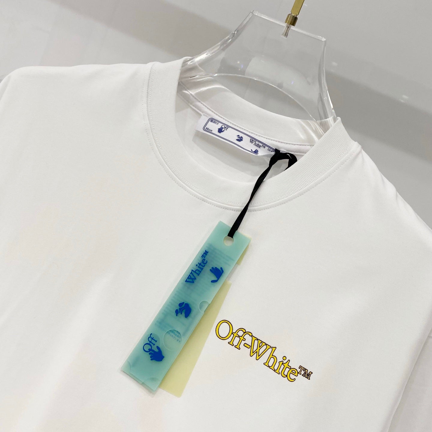 Off-White T-shirt front with yellow chest logo and hanging tag