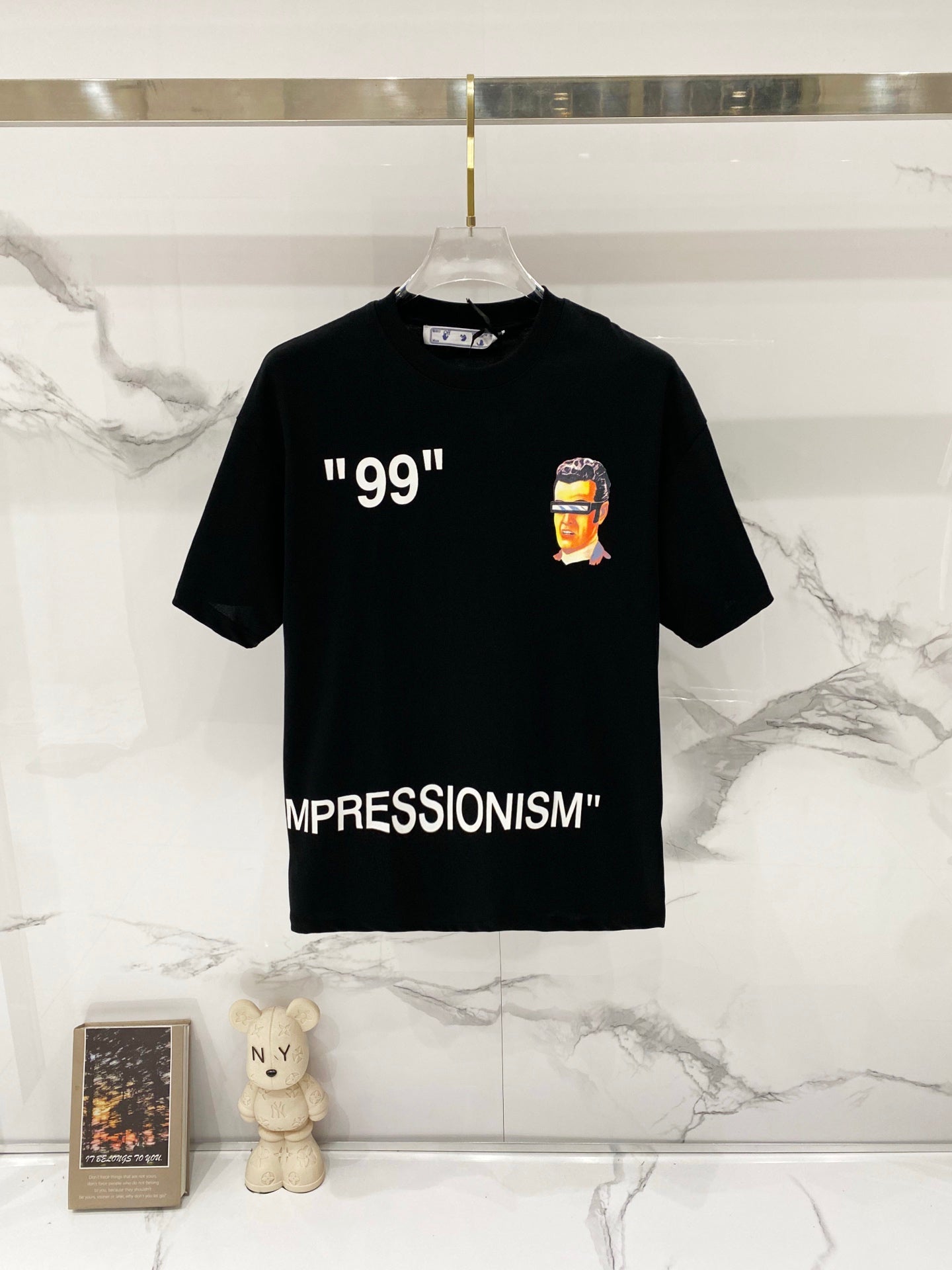 Off-White black graphic T-shirt with portrait and quote print, on hanger