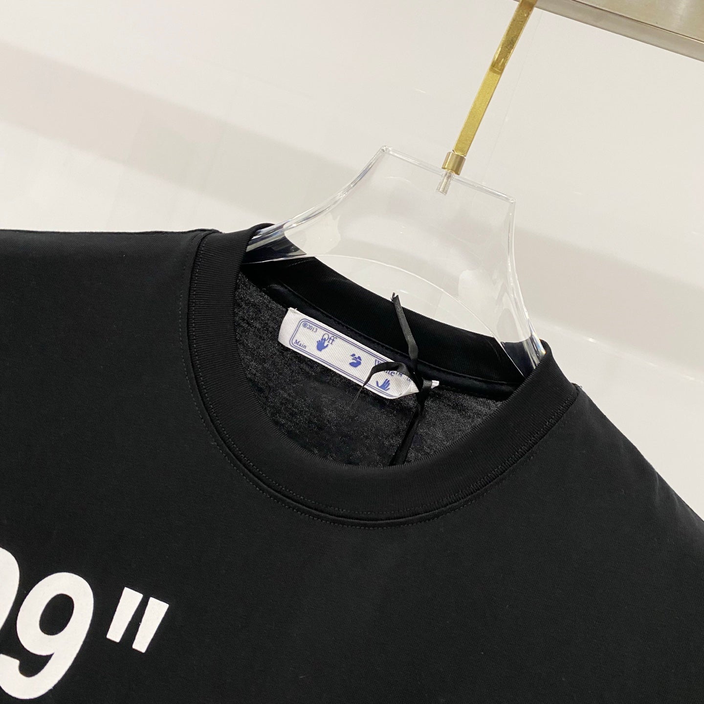 Off-White black T-shirt neckline close-up with inner tag and collar seam