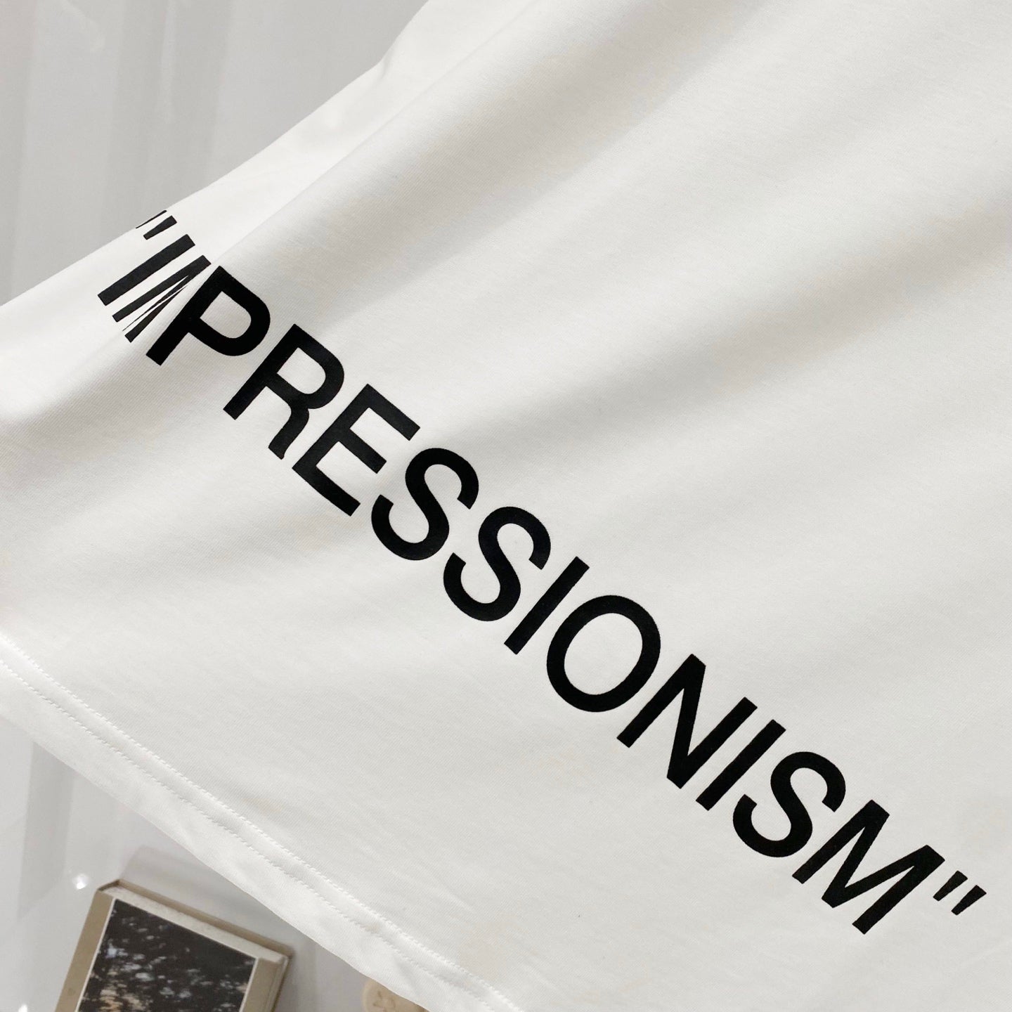 Off-white T-shirt with large 'IMPRESSIONSM' text print
