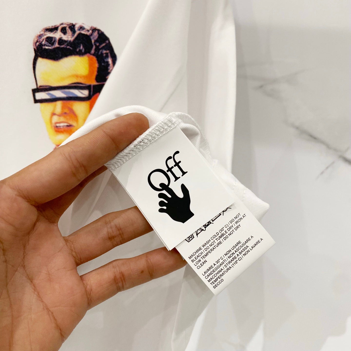 Off-white T-shirt hang tag with black logo and brand text