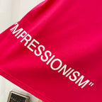 Off White red T-shirt close-up of “IMPRESSIONISM” text print across fabric.