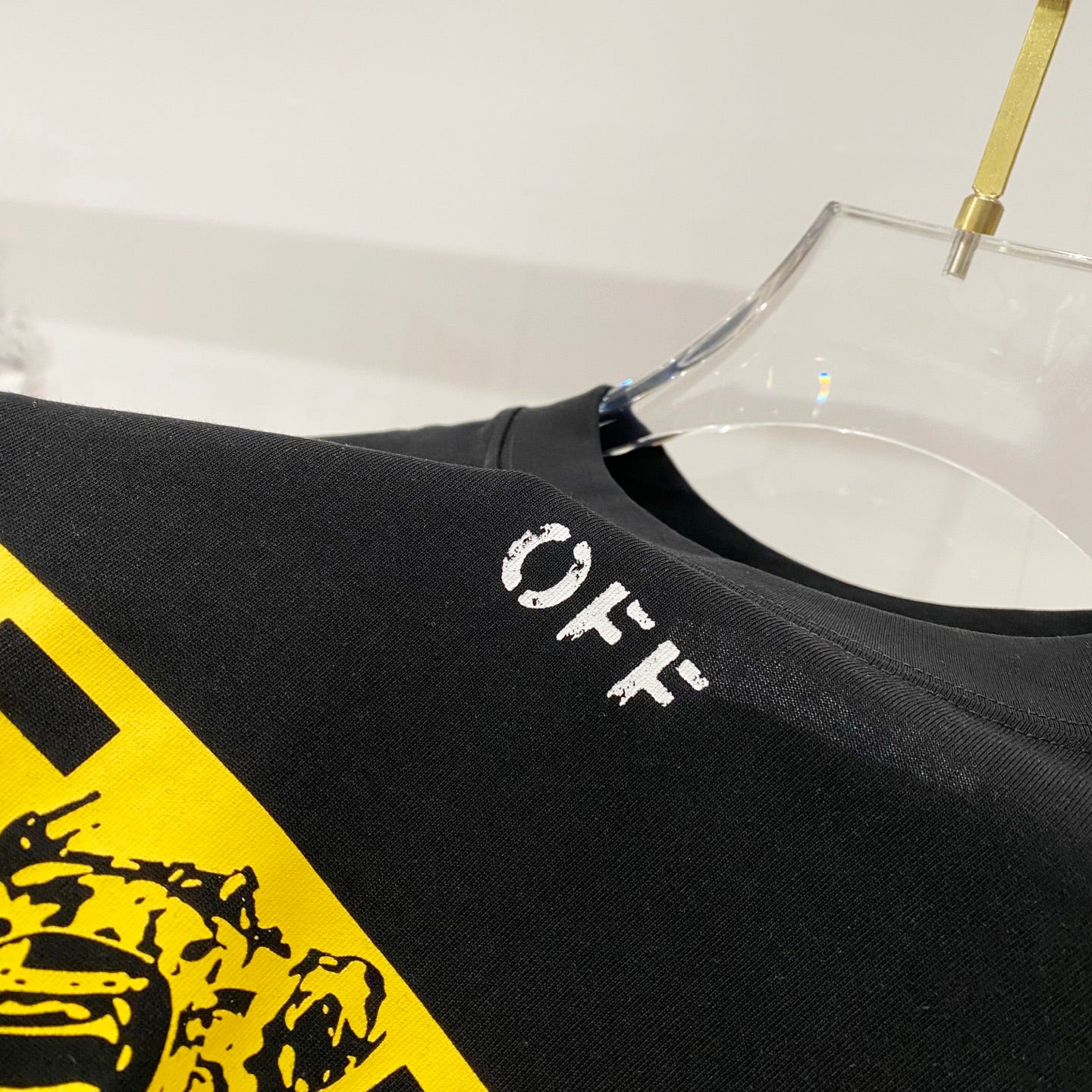 Off-White black T-shirt with small 'OFF' print near yellow graphic