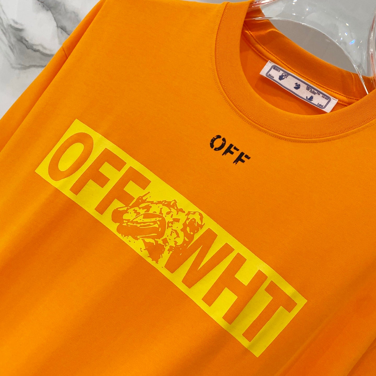 Orange T-shirt with slanted OFF-WHITE wordmark and distressed print