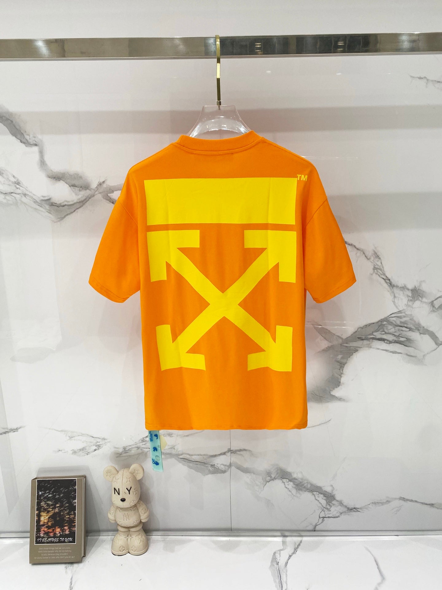 Orange T-shirt on hanger with large yellow back graphic print