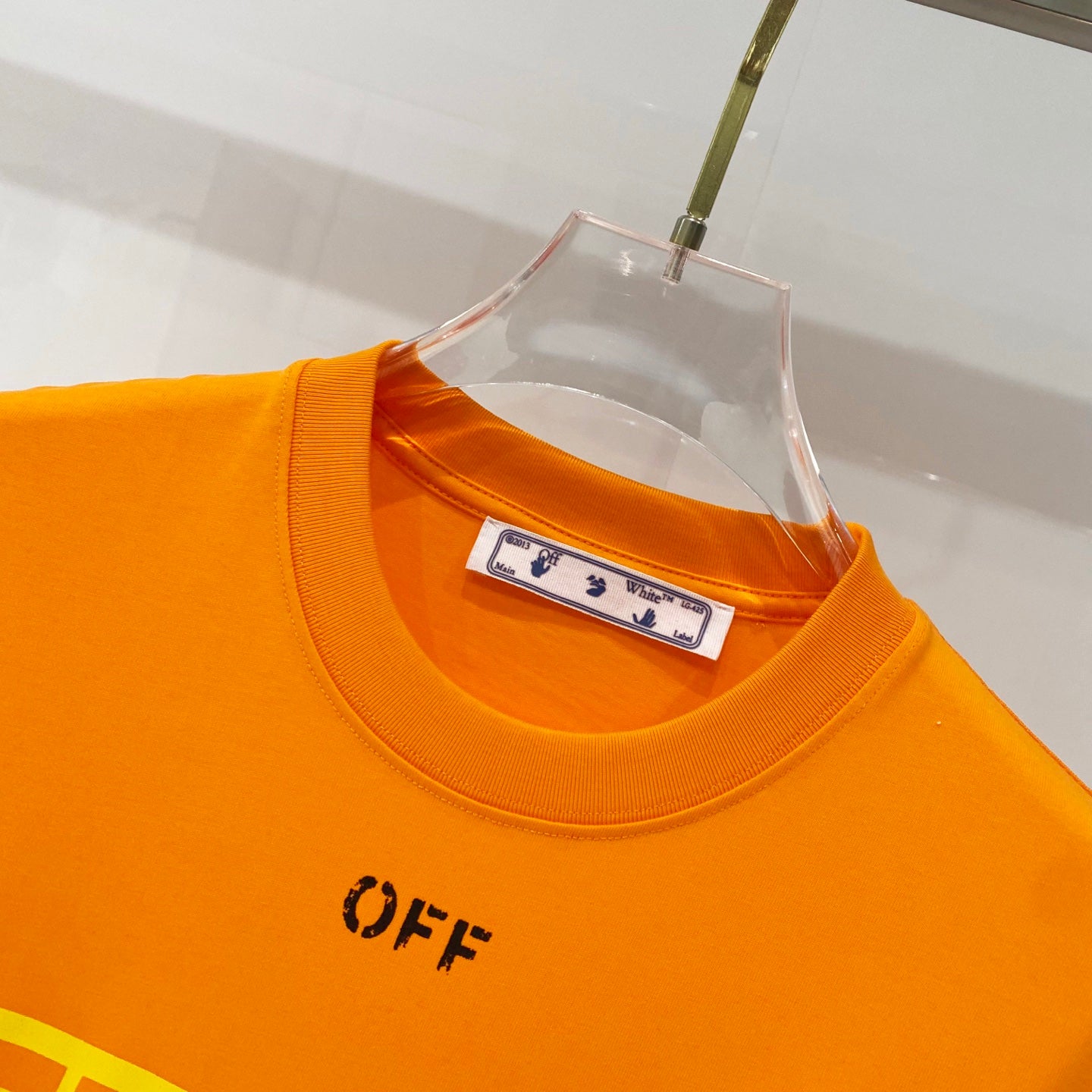 Orange crewneck T-shirt close-up with neck label and OFF logo