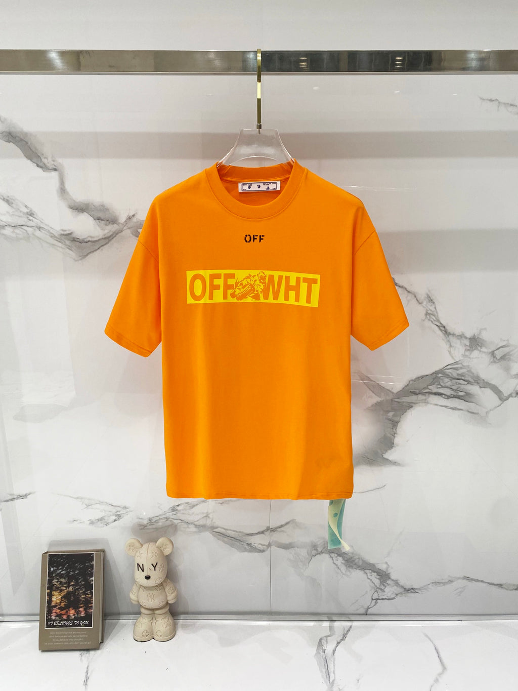 Orange T-shirt on hanger with OFF logo and OFF-WHITE chest print