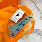 Orange T-shirt with hangtag and folded fabric items