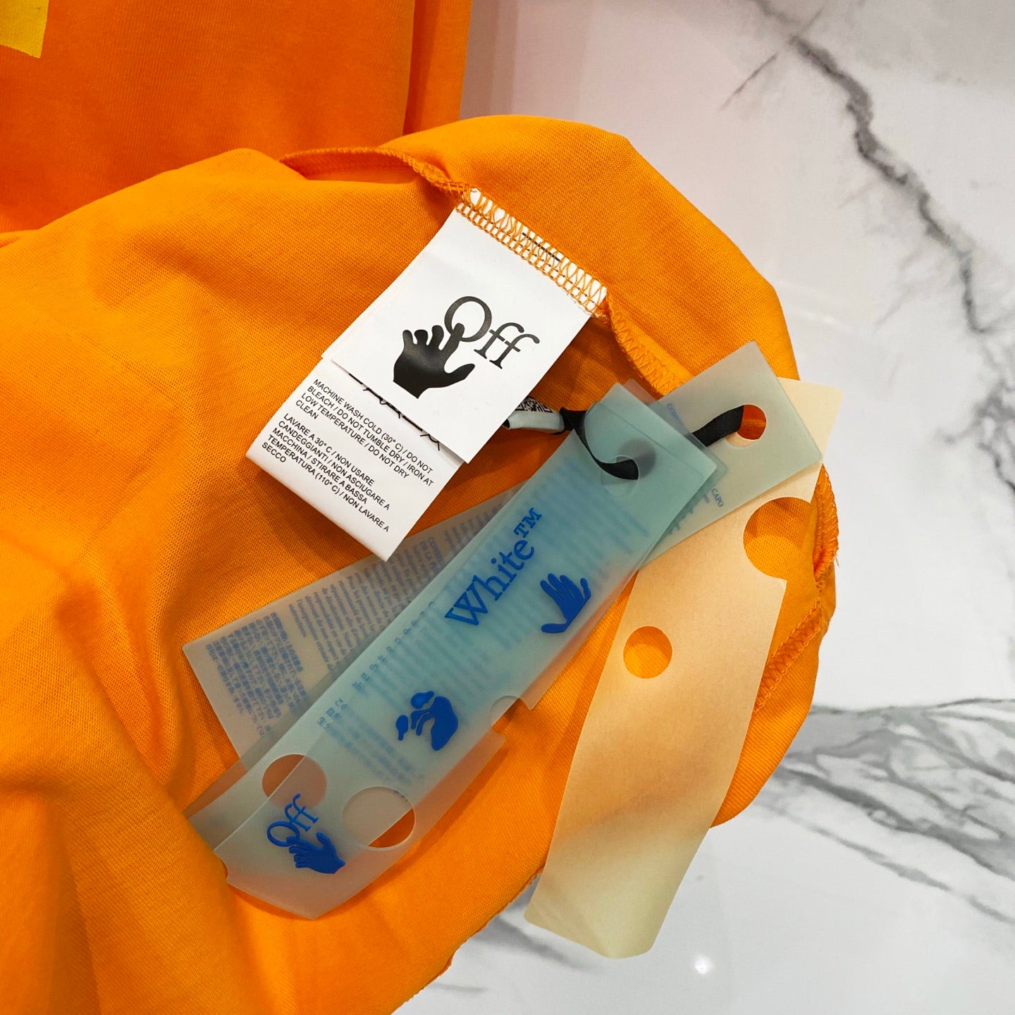 Orange T-shirt with hangtag and folded fabric items