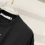 Off-White T-shirt upper front close-up, black crew neck and partial OFF print