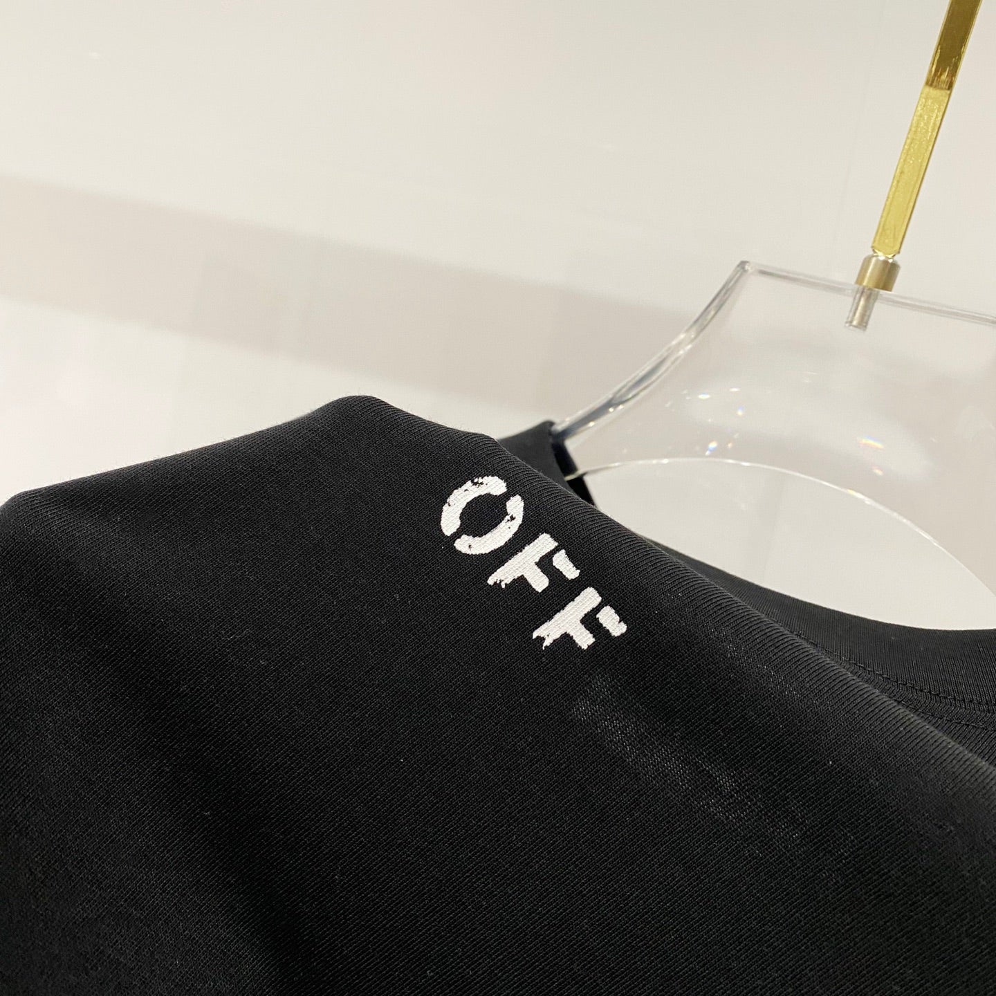 Off-White T-shirt shoulder close-up, black with small OFF lettering