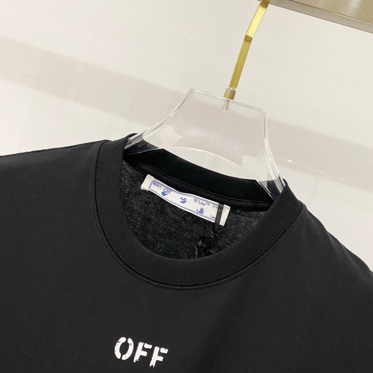 Off-White T-shirt neckline close-up, black crew neck with OFF logo on chest