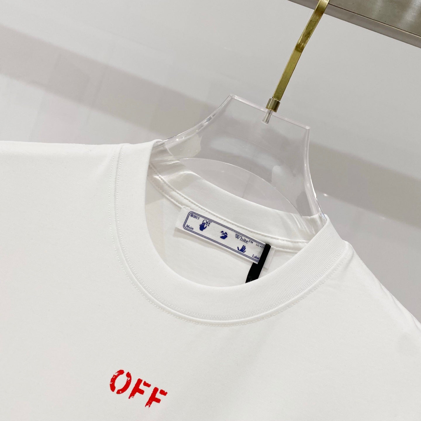 Off White off-white T-shirt close-up with red 'OFF' logo and crew neckline