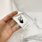 Off White off-white T-shirt care label with black logo text in hand