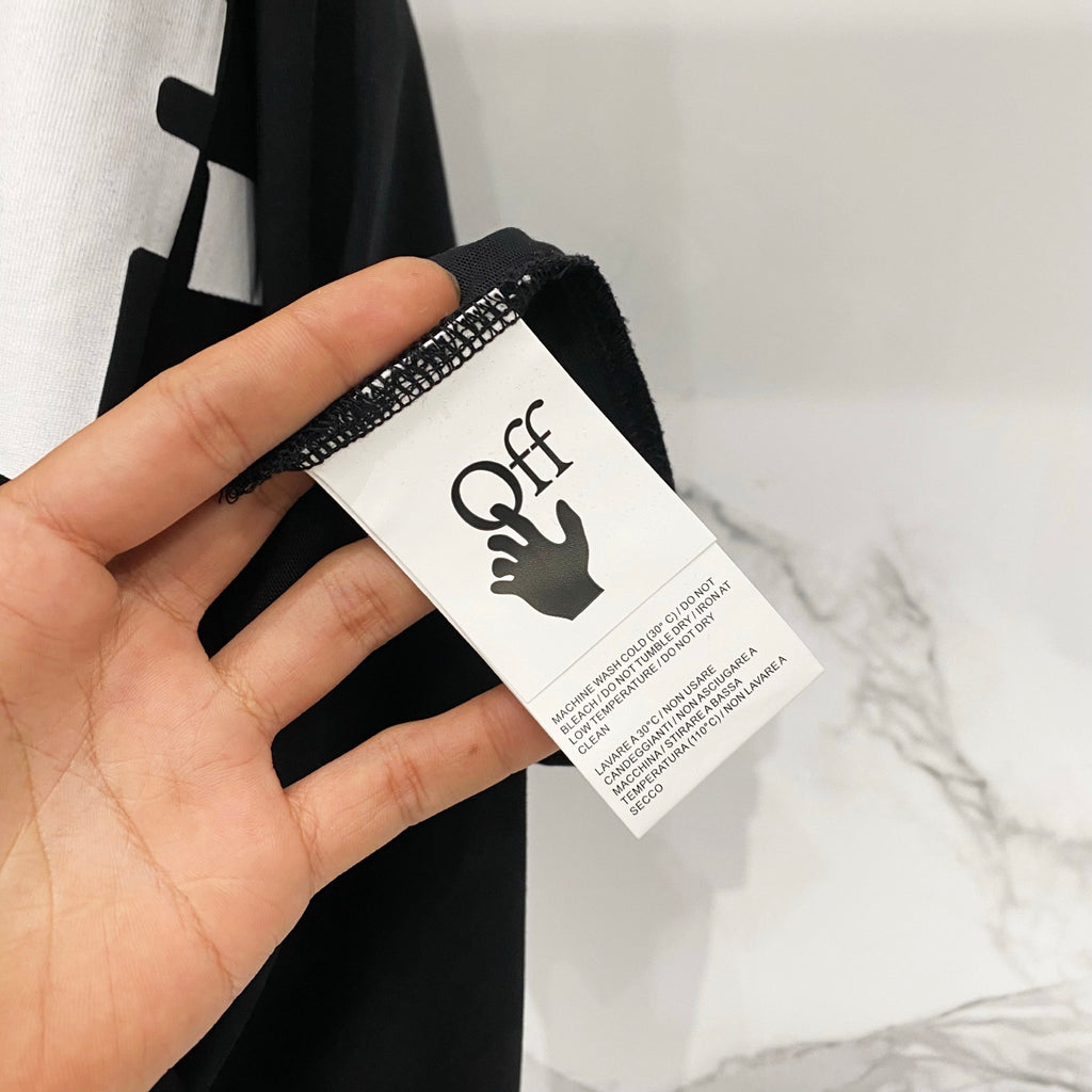 Off White T-shirt care label tag held in hand