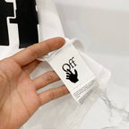 Off White T-shirt fabric label near collar seam held in hand