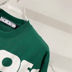Off-White T-shirt shoulder close-up, dark green with partial white logo graphic.