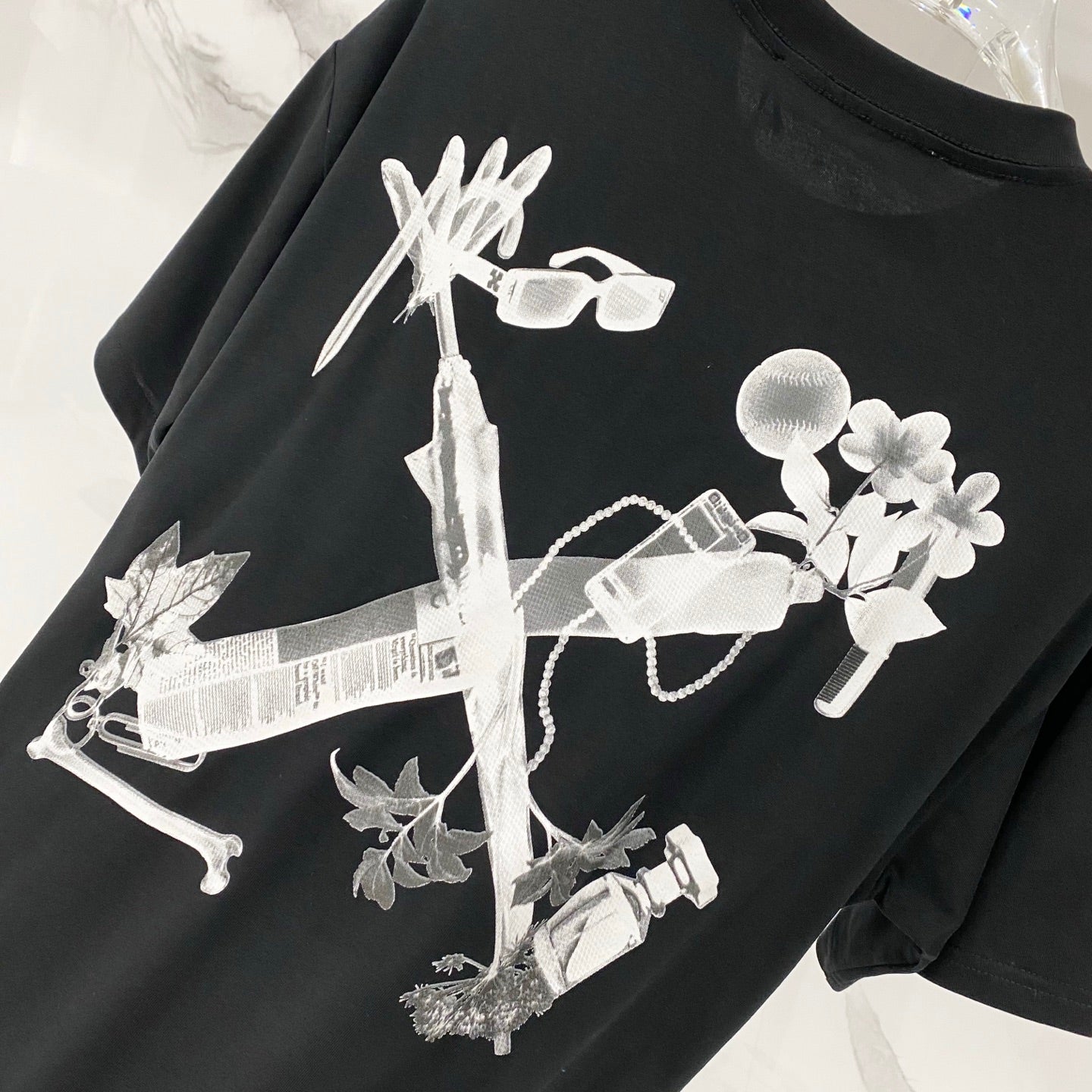 Black T-shirt with large white floral key-like graphic print