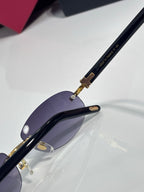 Cartier sunglasses with dark purple lenses and gold-trim temples, close-up