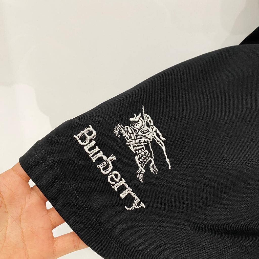 Burberry graphic T-shirt sleeve close-up with horse emblem and “Burberry” text.