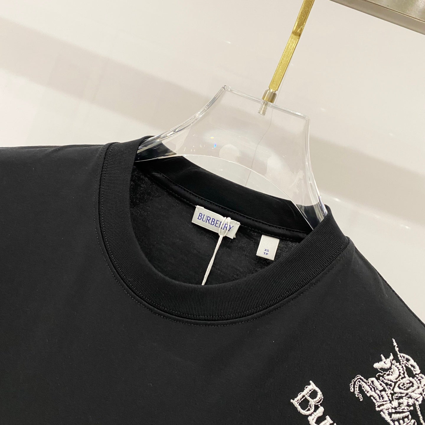 Burberry black crewneck T-shirt neckline close-up with brand tag inside collar.