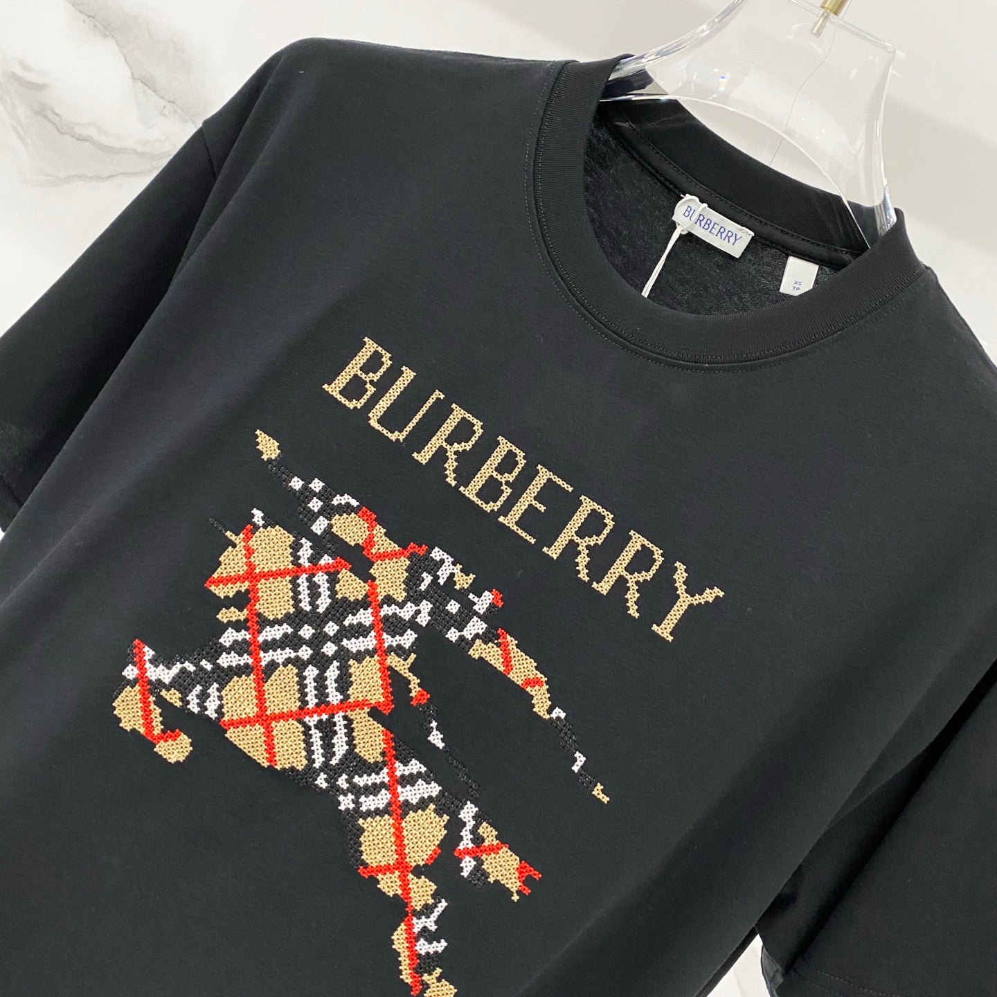Black short-sleeve T-shirt with gold Burberry text and multicolor emblem