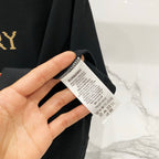 Black short-sleeve T-shirt care label held in hand