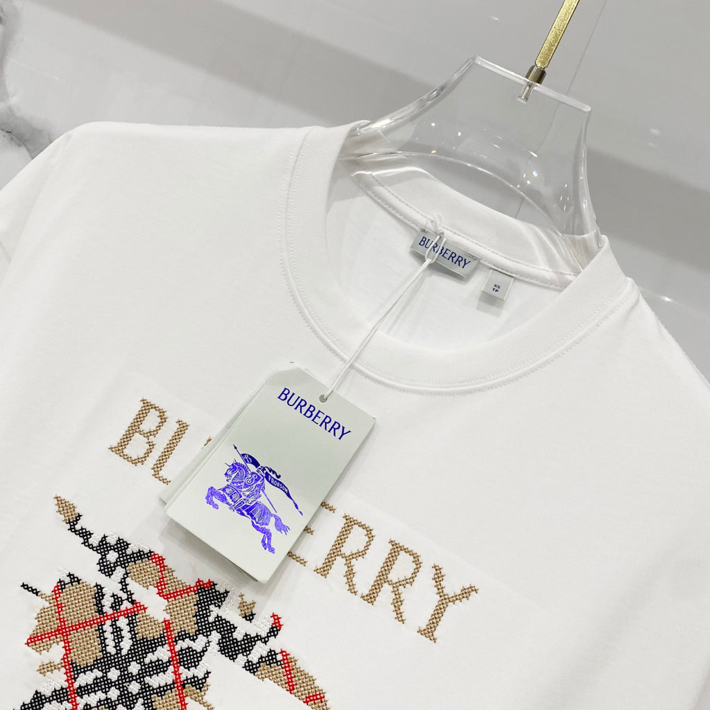 White Burberry T-shirt with gold logo text and small horse graphic on front