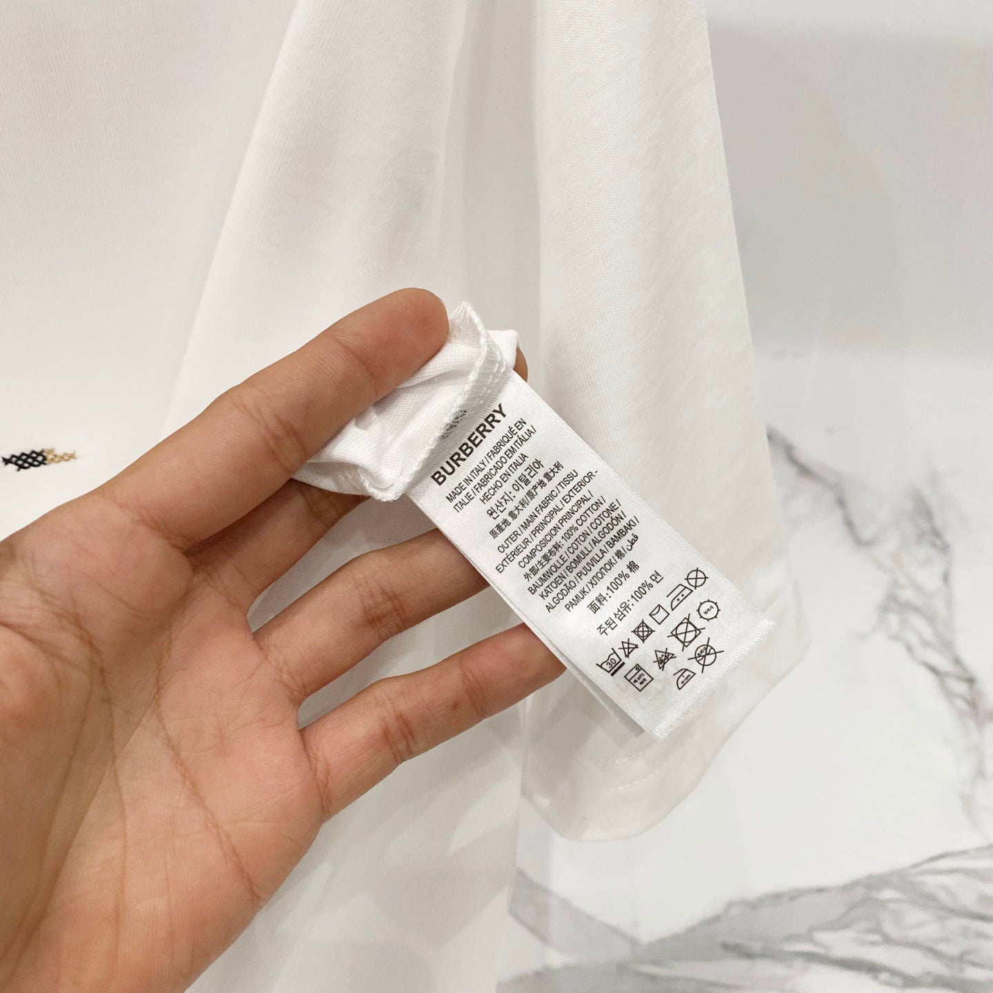 White Burberry T-shirt care label and brand tag close-up