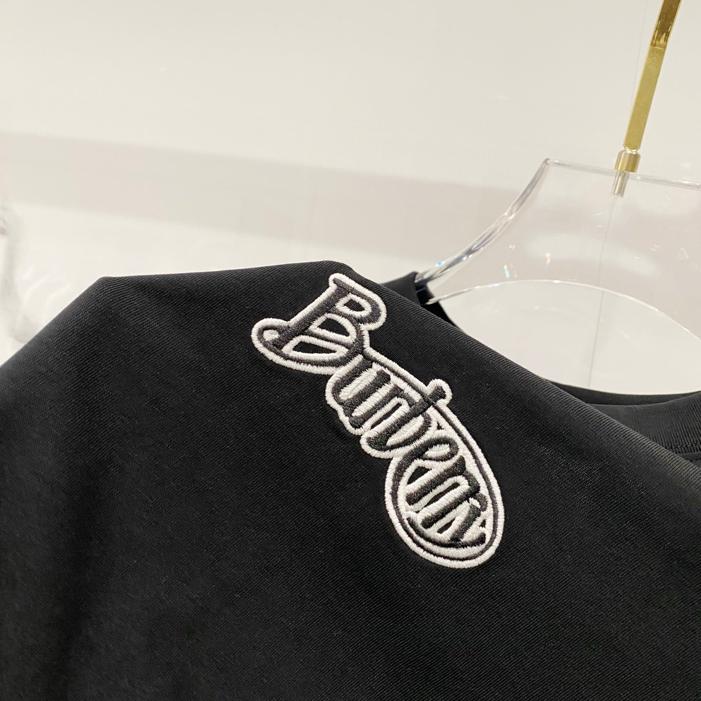 Black T-shirt with large embroidered logo on the sleeve