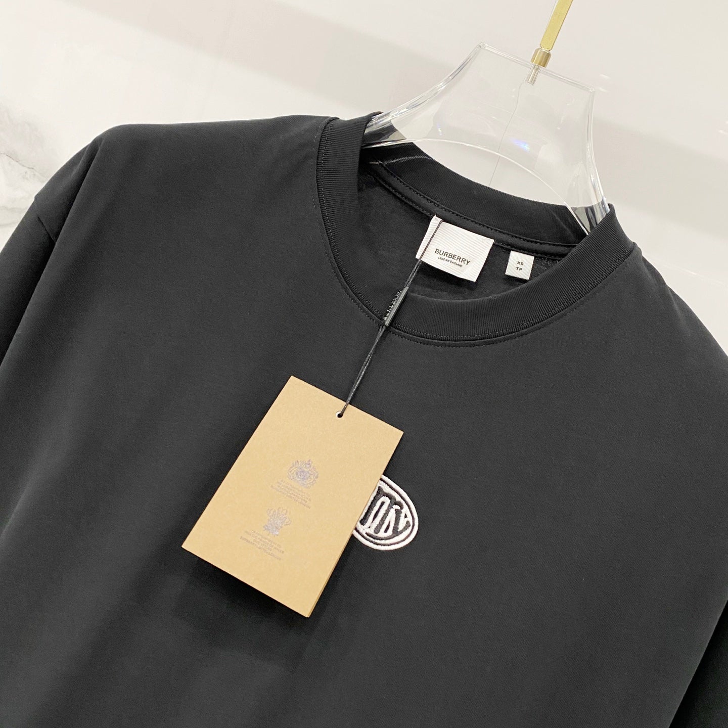 Black crewneck T-shirt with attached tag at the collar