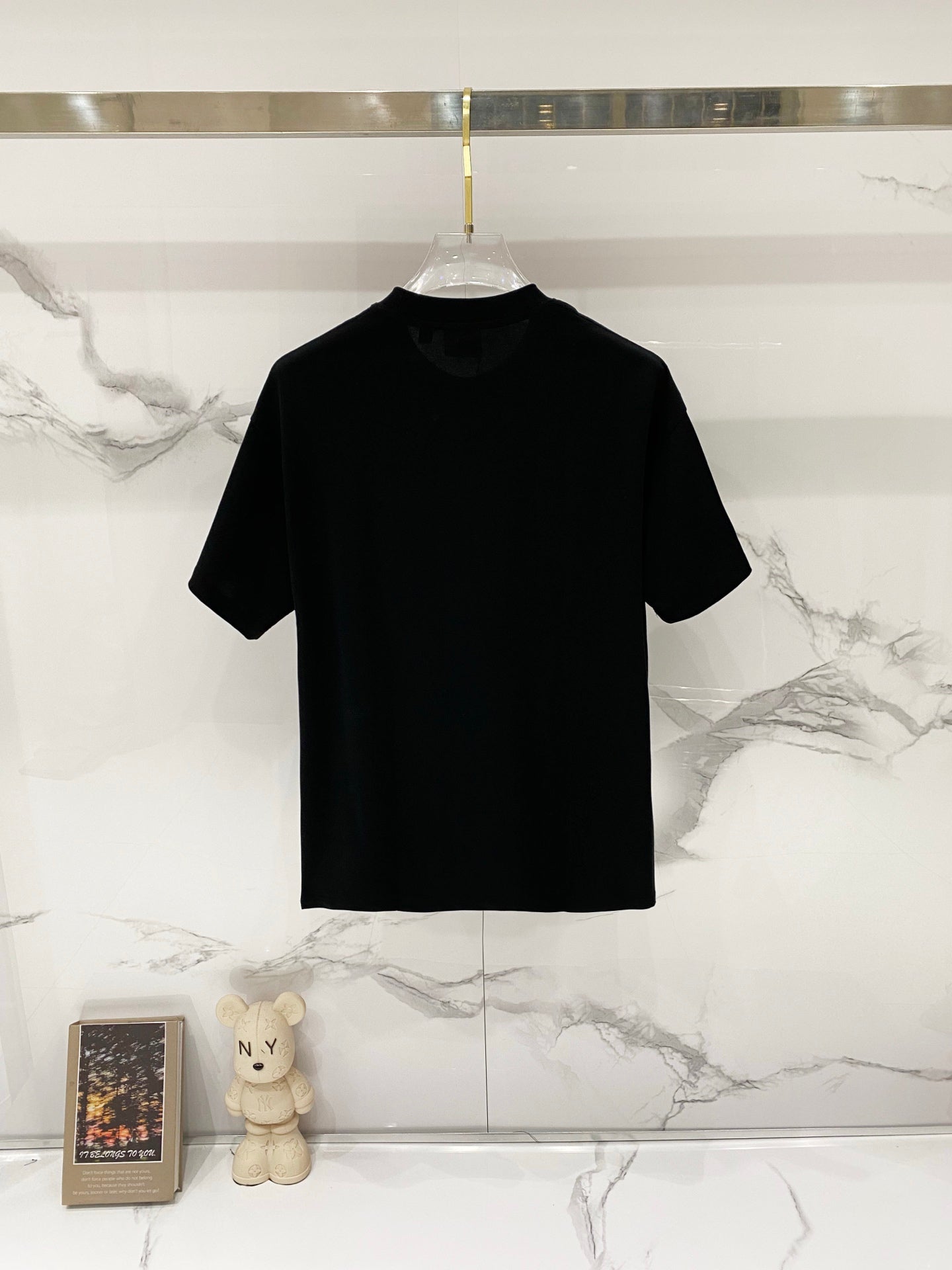Black crewneck short-sleeve T-shirt on a clear hanger