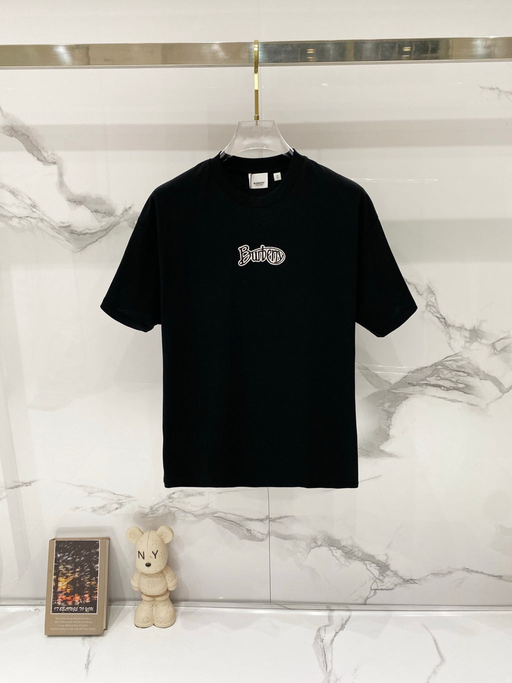 Black short-sleeve T-shirt with small embroidered logo on the chest