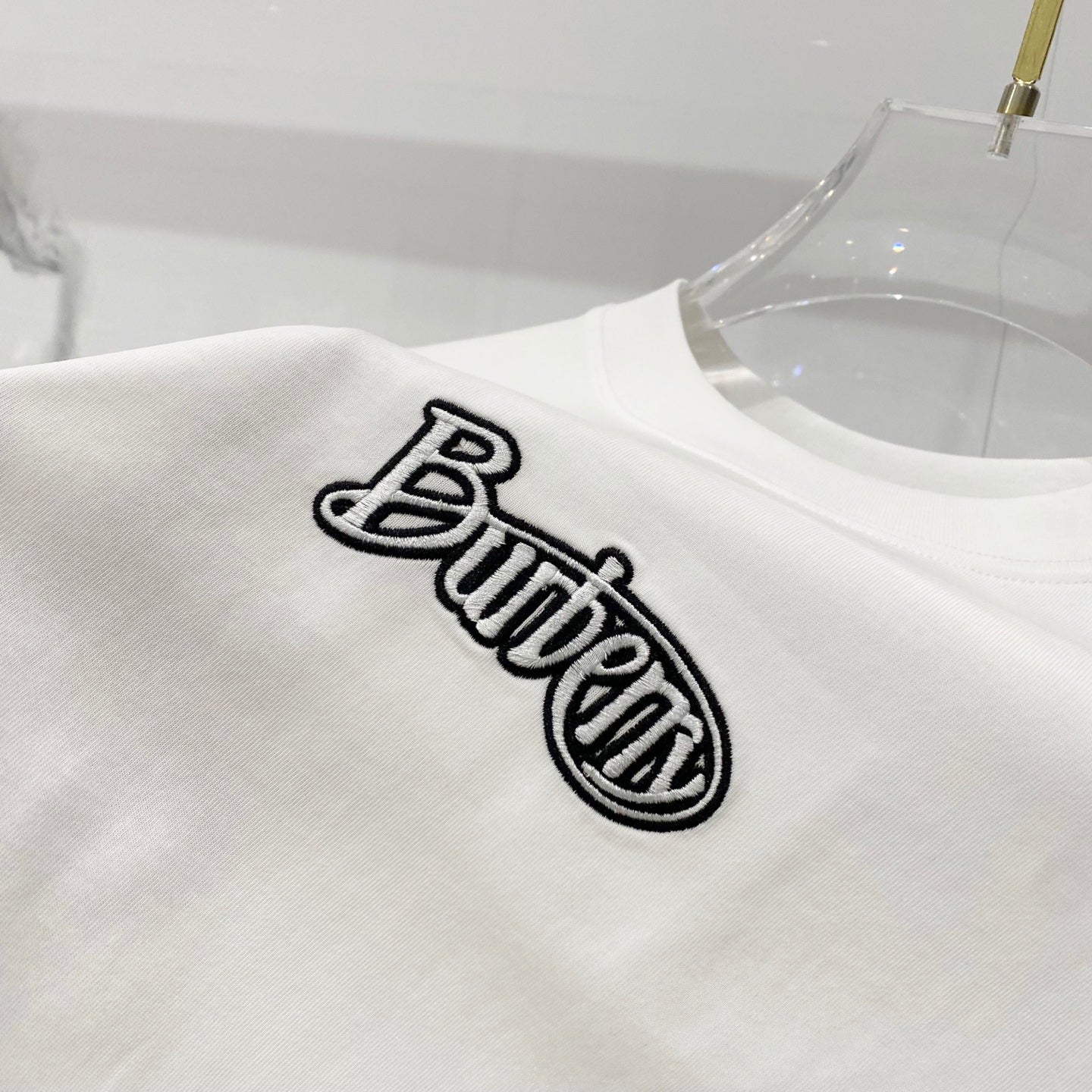 White short-sleeve T-shirt with embroidered-style black “Butter” logo on chest