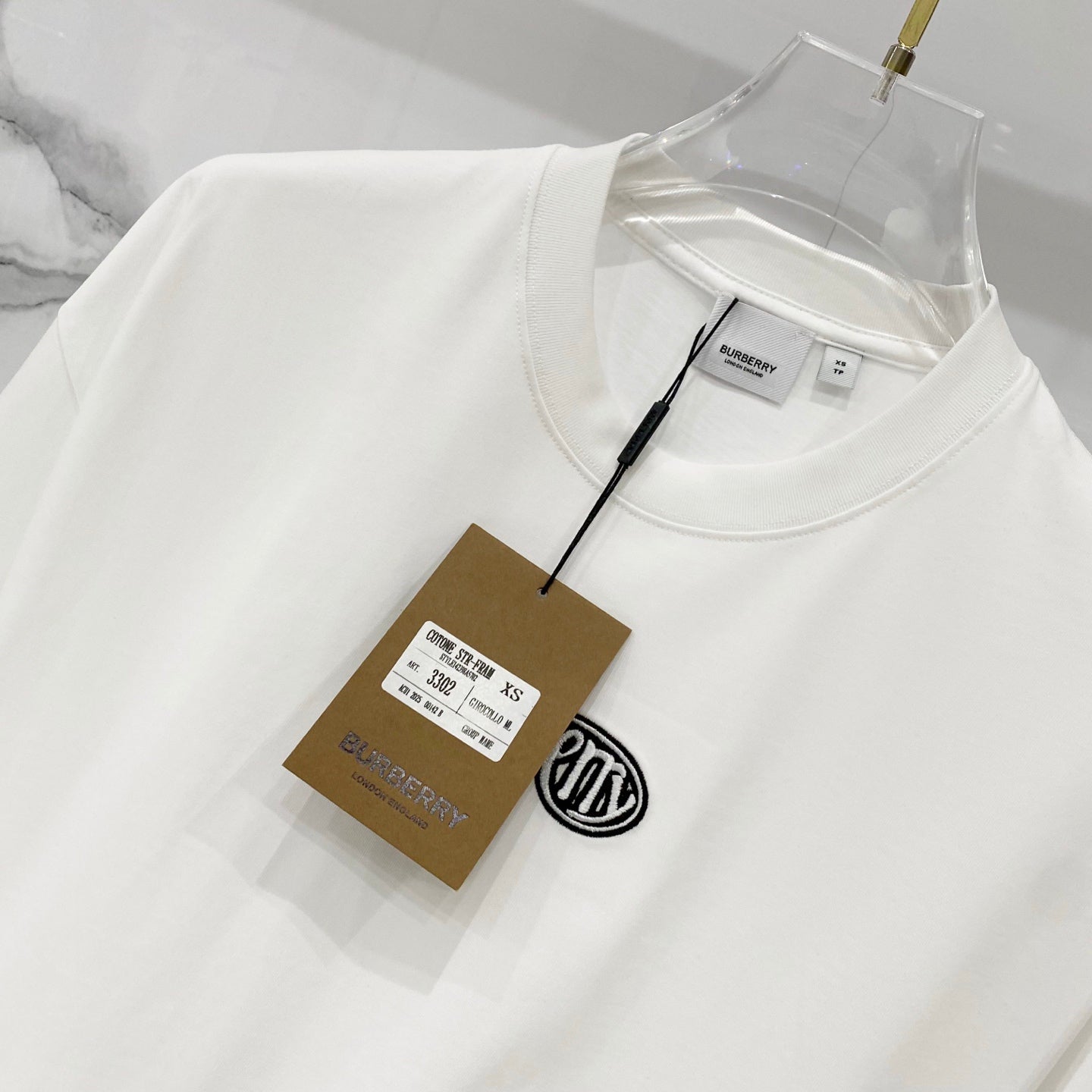 White short-sleeve T-shirt with “Butter” logo and hanging size/brand tag