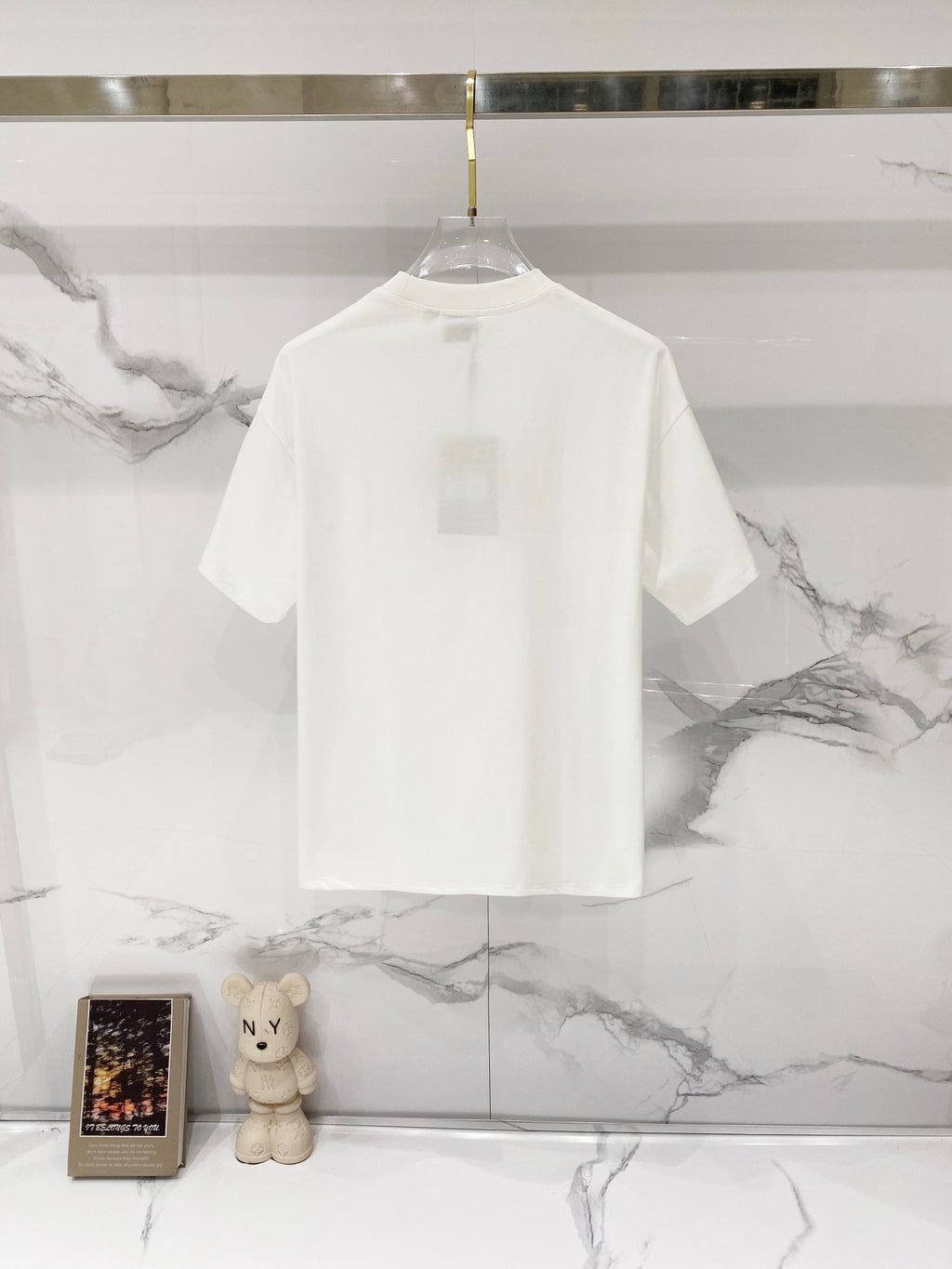 White short-sleeve T-shirt on hanger, back view with plain crew neckline