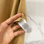 Tan T-shirt with care label tag shown near the side seam