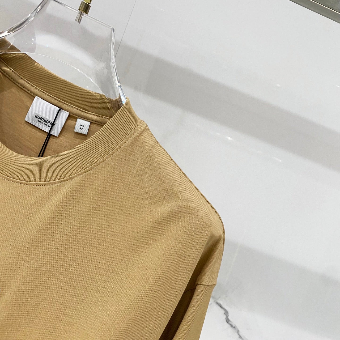 Tan short-sleeve T-shirt with round neckline and hang tags