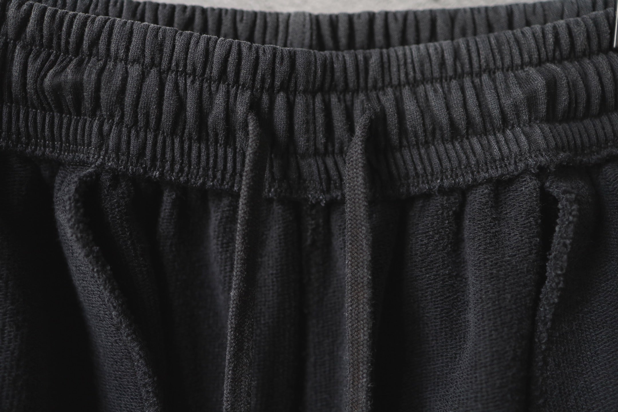 Dark gray cargo pants waistband with gathered elastic and seam lines